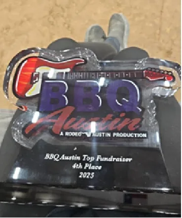 The BBQ Austin 4th Place Top Fundraiser award for 2025, a guitar-shaped acrylic trophy.