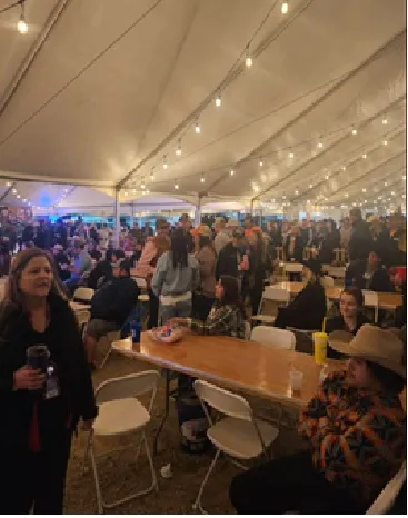 Volunteers and guests filling the event tent.